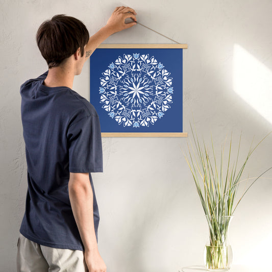This image is of a poster with hanger sold by New Wing Studio and features Mandala art inspired by the Bible verse “Be still, and know that I am God” Psalm 46:10. The words “be still” are hidden in this mandala 16 times. The print features a deep blue background with a white and light blue mandala floral design. The art is created by Jennifer Knight, NewWingStudio.com